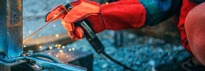 Person schweißt Metallteile